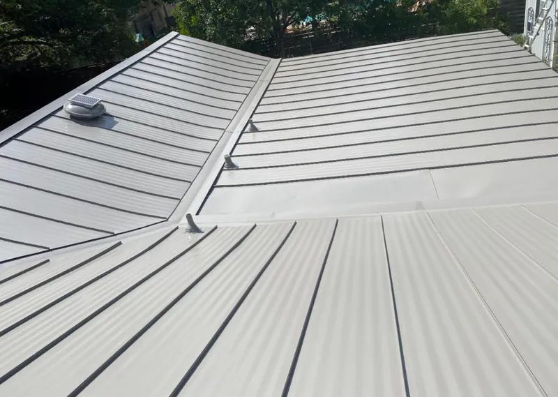 Solar attic fan installed on a metal roof for Roof Ventilation in Acton